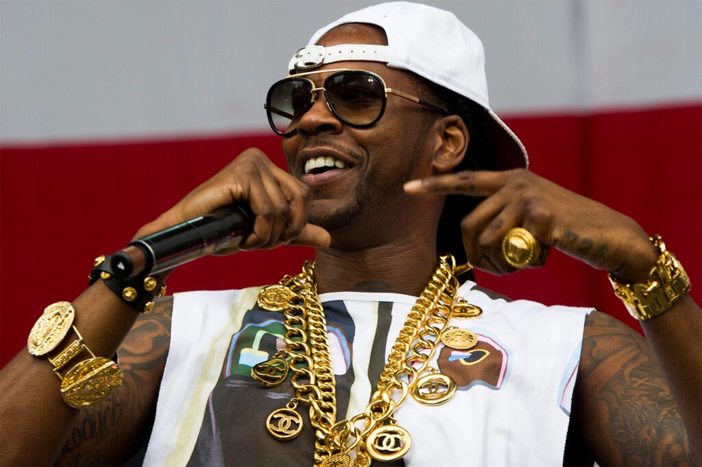 2 Chainz performing on stage with plenty of gold around his neck